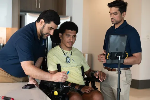 Kinemo co-founders Nordine Sebkhi and Arpan Bhavsar work with Wendell Odom during an assistive technology session using the Kinemo device to support independent computer and device control.